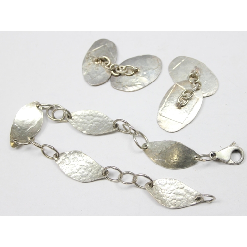 1158 - An Arts & Crafts style 925 silver bracelet of hammered form, the clasp marked and XRF tested and a p... 