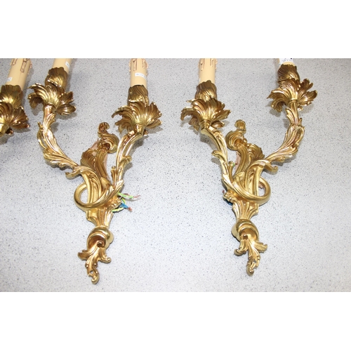 263 - A trio of Rococo style gilt brass double wall lights with candle effect sconces, each approx 43cm ta... 