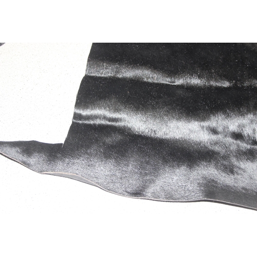 214 - Black bovine hide, approx 120cm x 80cm at widest points