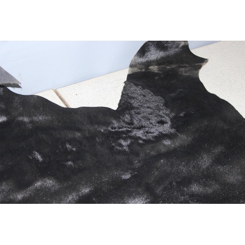 214 - Black bovine hide, approx 120cm x 80cm at widest points