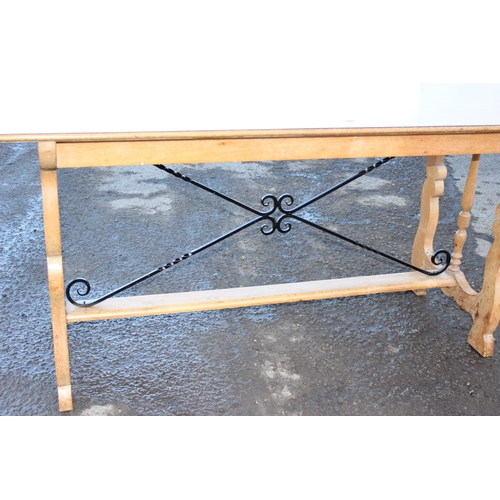 42 - An unusual light oak dining table with decorative wrought ironwork to base and matching Formica top,... 