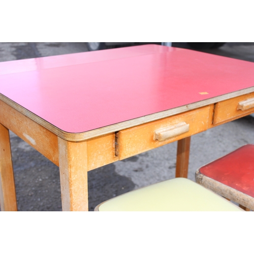 54 - A small mid-century Formica topped table with small drop flap and 2 drawers, and retro stools, the t... 