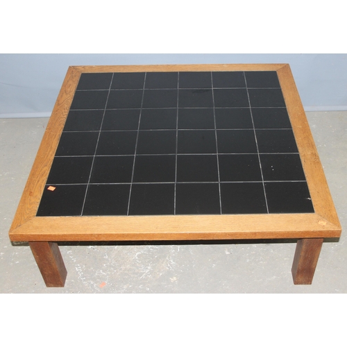 50A - A retro oak framed and black tile topped coffee table, approx 107cm wide x 107cm deep x 35cm tall