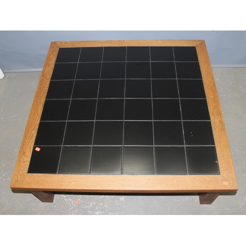 50A - A retro oak framed and black tile topped coffee table, approx 107cm wide x 107cm deep x 35cm tall