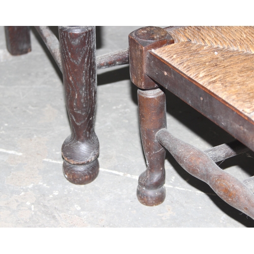 121 - An Arts & Crafts period oak armchair with rush seat and a matching footstool