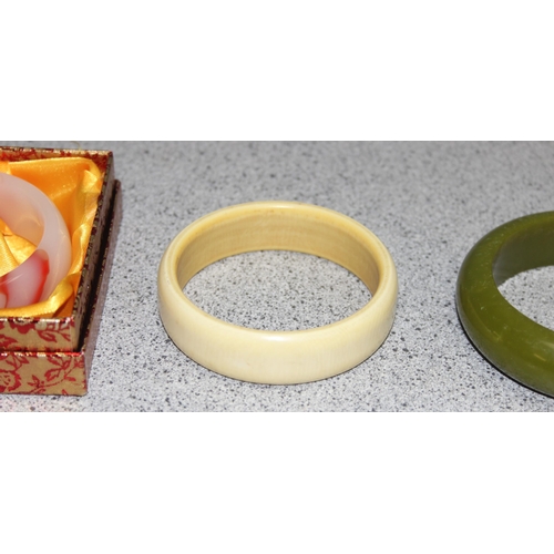 1109 - Boxed Chinese blood red and white polished jadeite bangle and two vintage Bakelite bracelets (3)