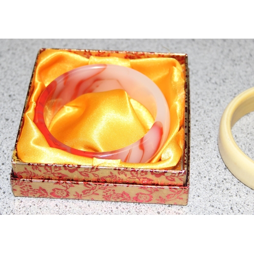 1109 - Boxed Chinese blood red and white polished jadeite bangle and two vintage Bakelite bracelets (3)