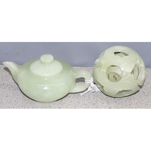 1603 - A Chinese carved green hardstone puzzle ball and a similar green hardstone teapot, the teapot approx... 