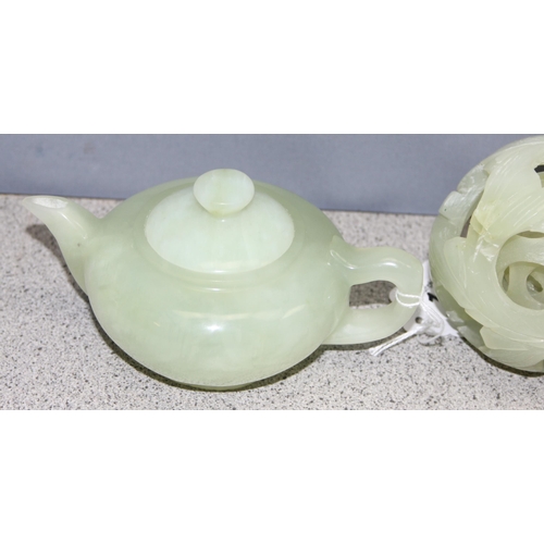 1603 - A Chinese carved green hardstone puzzle ball and a similar green hardstone teapot, the teapot approx... 