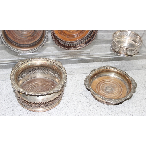 1087 - Assorted antique and later silver-plated items, mostly wine coasters chambersticks