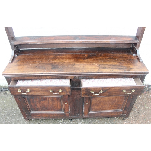 192 - An antique country oak dresser with plate rack, likely early 19th century, the base formed with 2 dr... 