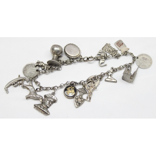 1144 - A vintage silver charm bracelet with 18 silver charms, approx 44.33g gross