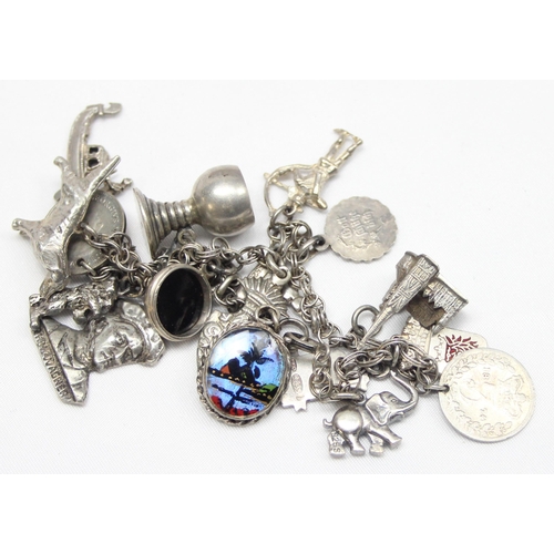 1144 - A vintage silver charm bracelet with 18 silver charms, approx 44.33g gross