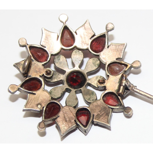 1146 - A Georgian style star shaped Garnet cluster brooch comprised of three tiers of mixed cut garnets in ... 