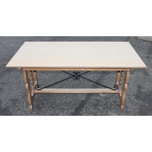 42 - An unusual light oak dining table with decorative wrought ironwork to base and matching Formica top,... 