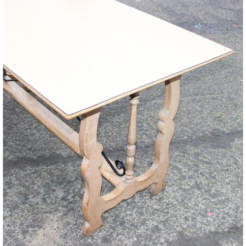 42 - An unusual light oak dining table with decorative wrought ironwork to base and matching Formica top,... 