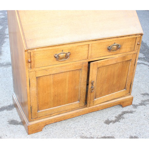 25 - An early 20th century light oak bureau, approx 107cm wide x 50cm deep x 104cm tall