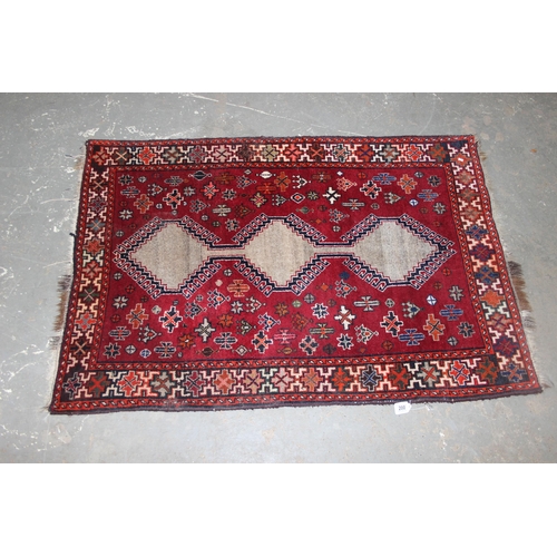 200 - A vintage red ground Persian rug, hand knotted, approx 162cm x 113cm