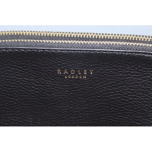 214 - A vintage Radley black leather handbag with dust bag and strap, approx 24cm wide