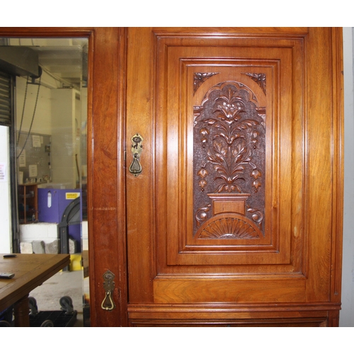 42 - An early 20th century mahogany gentleman's wardrobe with carved details and mirrored drawer, the rig... 