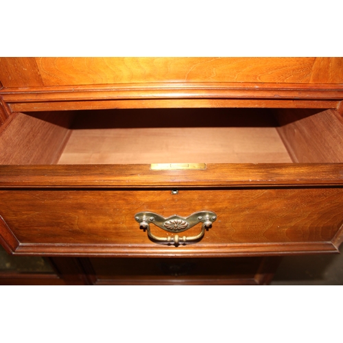 42 - An early 20th century mahogany gentleman's wardrobe with carved details and mirrored drawer, the rig... 