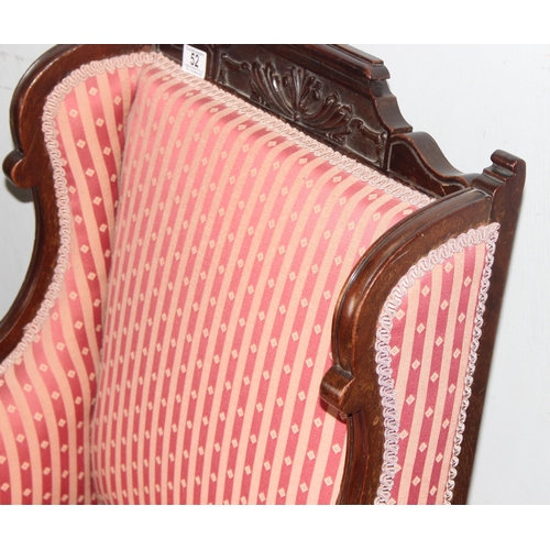 52 - A 19th century high backed armchair with striped upholstery and mahogany frame with carved details