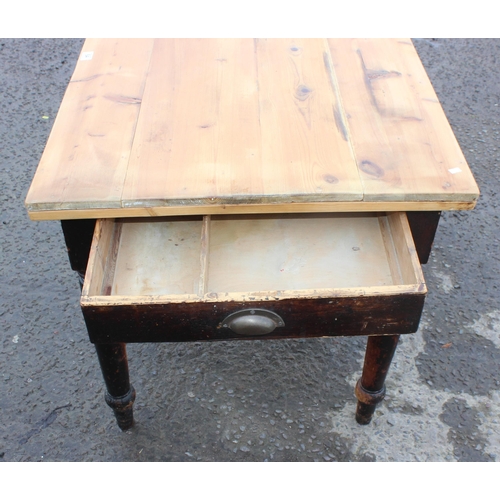 64 - A rustic pine farmhouse kitchen table with single drawer, scrubbed pine top and stained base, approx... 