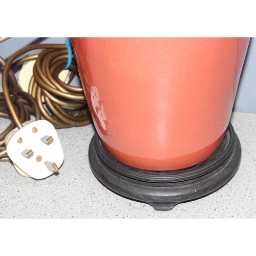 249 - Pair of Chinese style shaped pottery lamps on wooden base, in a orange/red terracotta colour, approx... 