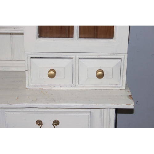 13 - A large vintage painted pine dresser, the base with 3 drawers over 3 cupboards and the top with 2 gl... 