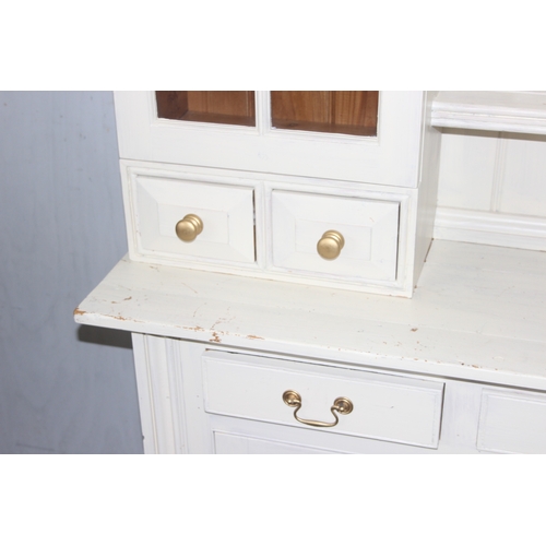 13 - A large vintage painted pine dresser, the base with 3 drawers over 3 cupboards and the top with 2 gl... 