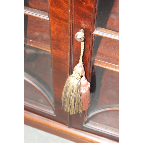 21 - An antique style glazed mahogany bookcase, approx 122cm wide x 32cm deep x 100cm tall