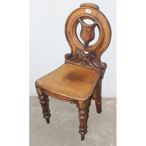 26 - An antique oak hall chair with carved round back, approx 92cm tall