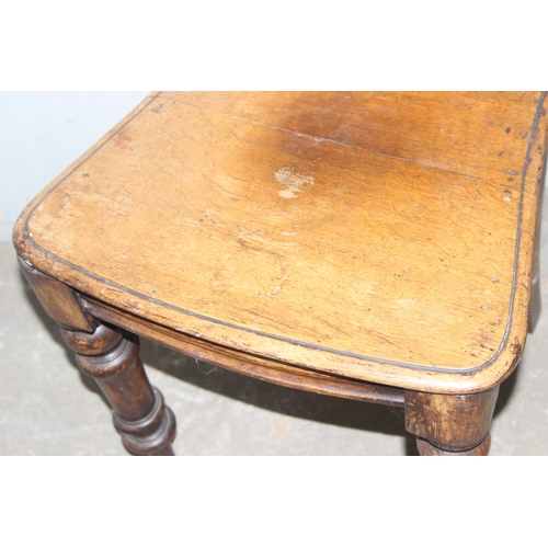 26 - An antique oak hall chair with carved round back, approx 92cm tall