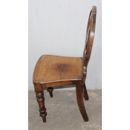 26 - An antique oak hall chair with carved round back, approx 92cm tall