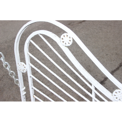 302 - An impressive wrought iron and white painted swing garden seat or bench with planted pillars, approx... 