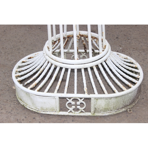 302 - An impressive wrought iron and white painted swing garden seat or bench with planted pillars, approx... 