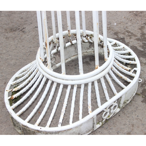 302 - An impressive wrought iron and white painted swing garden seat or bench with planted pillars, approx... 