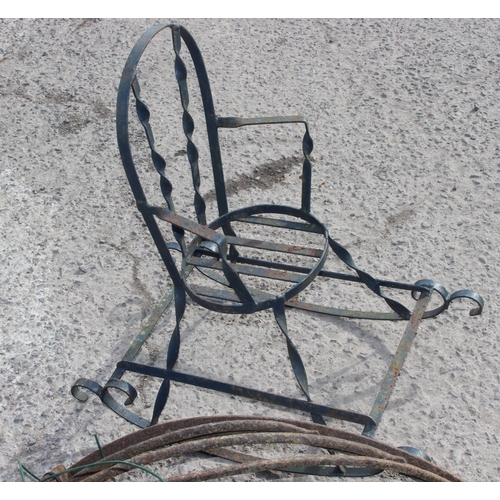 322 - A large vintage painted Kettle, cast iron hay feeder and a wrought iron miniature rocking chair, the... 