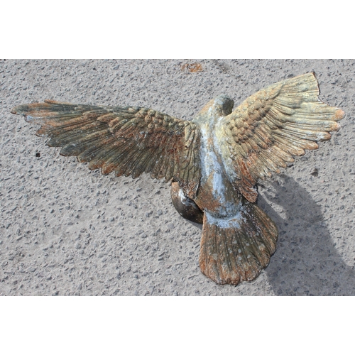 331 - A life size weathered cast iron model of an eagle on rocky base, 20th century, approx 61cm wide x 53... 