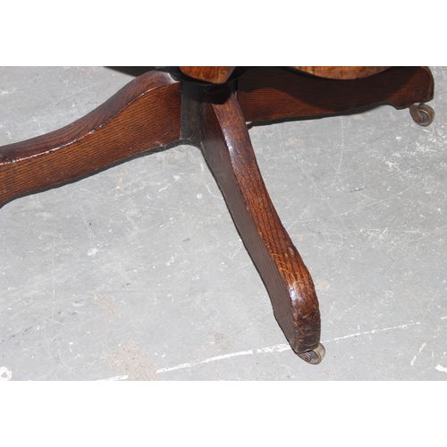 34 - A vintage oak desk or swivel chair with studded leather seat, approx 58cm wide x 81cm tall