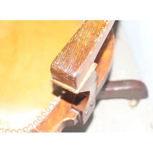 34 - A vintage oak desk or swivel chair with studded leather seat, approx 58cm wide x 81cm tall