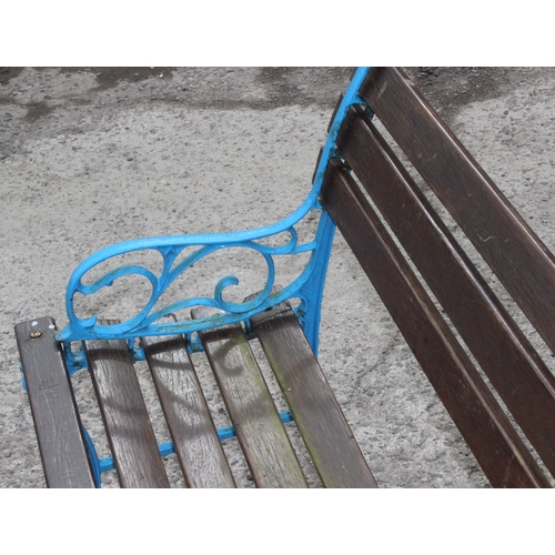 343 - A wooden slatted garden bench with blue painted cast iron ends, approx 123cm wide