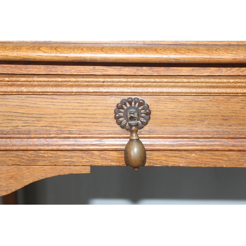 46 - An early 20th century oak side table with 2 drawers, approx 106cm wide x 47cm deep x 72cm tall