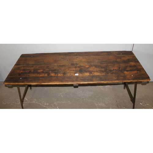 100 - A vintage wooden topped folding trestle table with metal base likely c.1930, approx 181cm wide x 68c... 