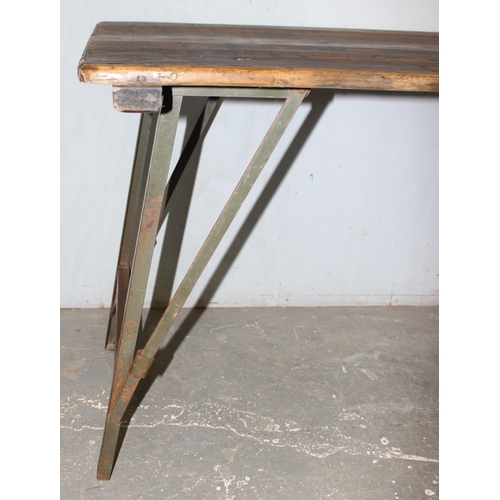 100 - A vintage wooden topped folding trestle table with metal base likely c.1930, approx 181cm wide x 68c... 