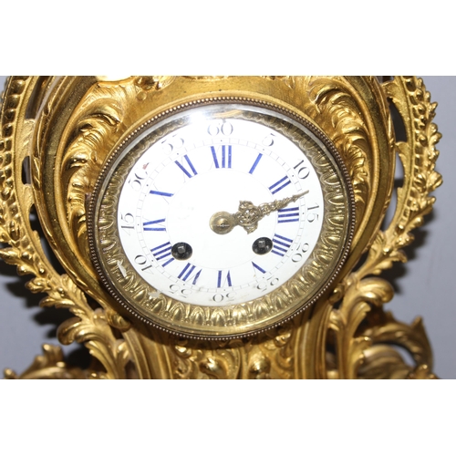 1321 - A highly decorative French brass clock garniture, a highly decorative Rococo style clock flanked by ... 