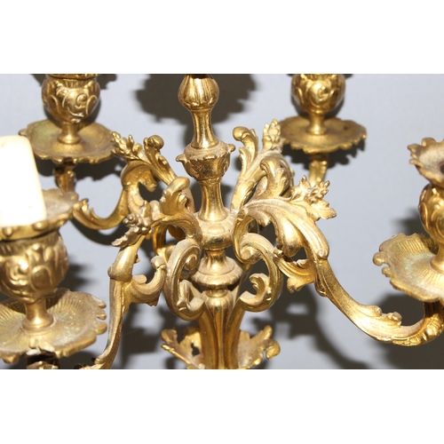 1321 - A highly decorative French brass clock garniture, a highly decorative Rococo style clock flanked by ... 