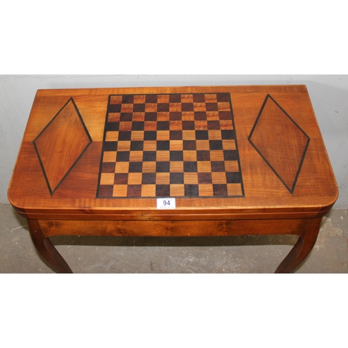 94 - A vintage inlaid wooden games and card table with fold over top, the top inlaid with chessboard styl... 