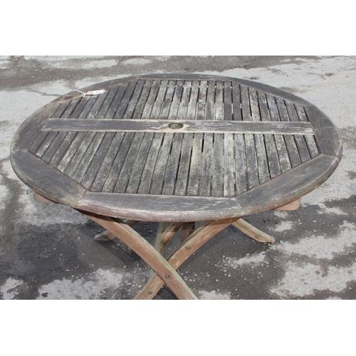 366 - A circular teak garden table and 2 directors style chairs, approx 108cm wide x 108cm deep x 74cm tal... 