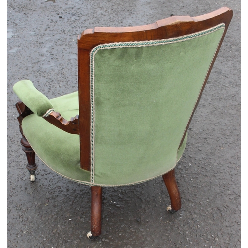 124 - A 19th century button back low chair with mahogany show frame and green upholstery